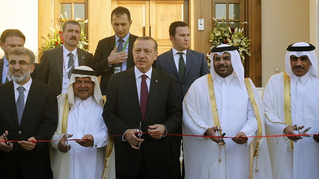 QATAR/ Turkey's Prime Minister Tayyip Erdogan (C) cuts the ribbon during the opening ceremony of the new building of the Turkish Embassy in Doha December 4, 2013. REUTERS/Mohammed Dabbous (QATAR - Tags: POLITICS) - RTX163G5