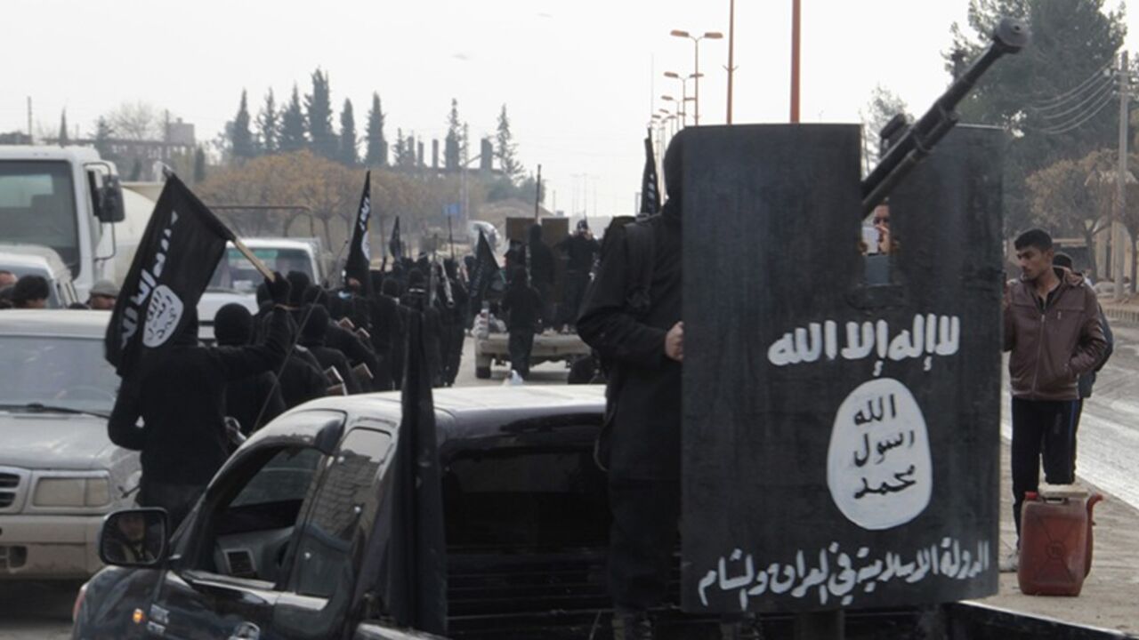 SYRIA-CRISIS/ Fighters of the al-Qaeda linked Islamic State of Iraq and the Levant wave flags as they take part in a parade, while a fellow fighter stands on the back of a truck at the Syrian town of Tel Abyad, near the border with Turkey January 2, 2014. Picture taken January 2, 2014. REUTERS/Yaser Al-Khodor (SYRIA - Tags: POLITICS CIVIL UNREST) - RTX170TT