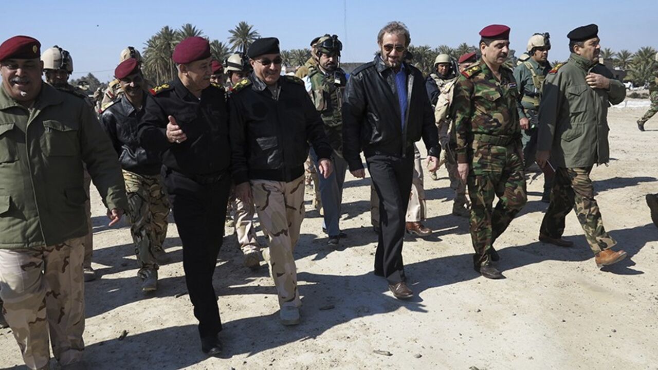 IRAQ-VIOLENCE/ Iraqi acting Defence Minister Saadoun al-Dulaimi (3rd R) walks with army officers during the tour in Anbar province, February 7, 2014. ISIL militants and other Sunni groups angered by the Shi'ite-led government overran Falluja and parts of the nearby city of Ramadi in the western province of Anbar on Jan. 1. REUTERS/Stringer (IRAQ - Tags: CIVIL UNREST MILITARY) - RTX18DJ1