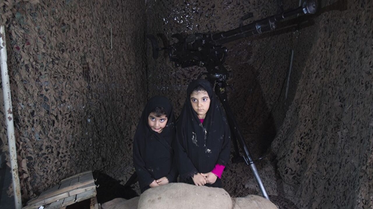 IRAN/ EDITORS' NOTE: Reuters and other foreign media are subject to Iranian restrictions on their ability to film or take pictures in Tehran.
Two girls pose for a photograph as they sit at a mock shelter at a war exhibition held by Iran's Basij militia and revolutionary guard to mark the anniversary of the Iran-Iraq war (1980-88), also known in Iran as the "Holy Defence", at a Revolutionary Guards military base in south-eastern Tehran September 23, 2010. The base, also known as the Resistance Village, is used a