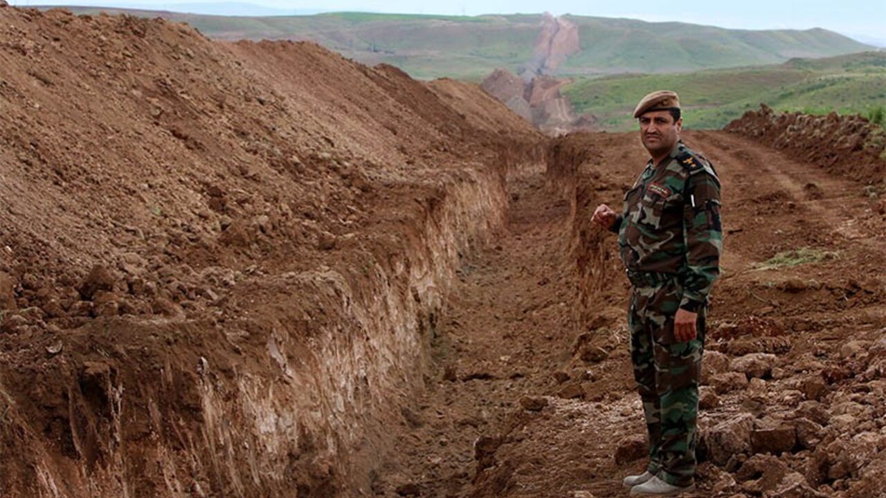 Nic6317047 A member of Iraqi security forces looks on during the digging operations to build a trench on the northern Iraqi border with Syria to prevent people from crossing over into Iraq's autonomous Kurdistan region, on April 13, 2014 in Zakho. AFP PHOTO/SAFIN HAMED (Photo credit should read SAFIN HAMED/AFP/Getty Images)