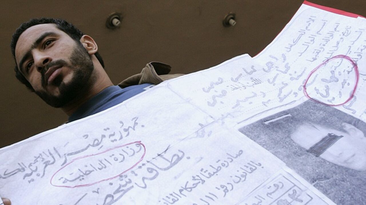 EGYPT-BAHA'I/ A demonstrator holds placards featuring Baha'i identity cards at a protest in front of the Court of the State Council in Cairo December 16, 2006, to show support for the Baha'i community in Egypt. An Egyptian court on Saturday overturned a lower court ruling that gave the country's small Baha'i community the right to identify themselves as Baha'is on official documents such as identity cards. REUTERS/Nasser Nuri (EGYPT) - RTR1KGZW