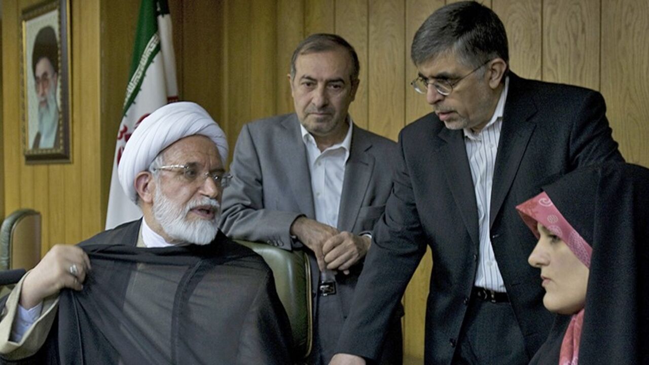 IRAN-ELECTION/ Iranian presidential candidate Mehdi Karoubi adjusts his clerical cloak as he speaks with advisors Morteza Alviri (2nd L), Gholamhossein Karbaschi and Jamileh Kadivar (R) before a news conference in Tehran June 9, 2009. Iranians vote in a presidential election on June 12. REUTERS/Raheb Homavandi (IRAN POLITICS ELECTIONS) - RTR24H26