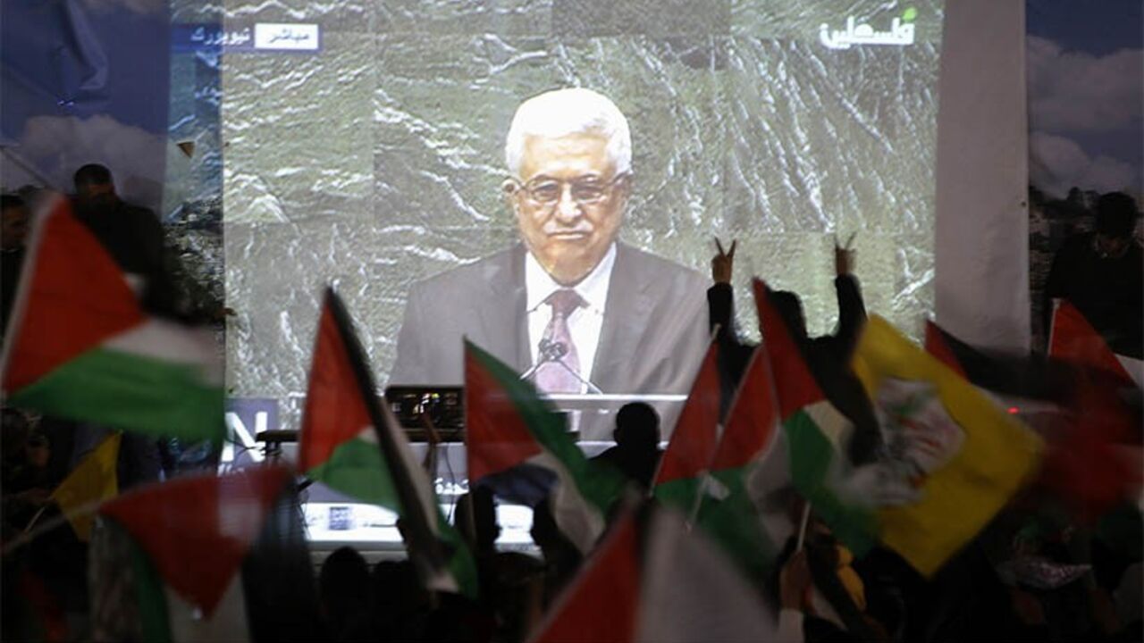 PALESTINIANS-STATEHOOD/ABBAS Palestinians take part in a rally while the speech of Palestinian President Mahmoud Abbas is being projected in the West Bank city of Ramallah November 29, 2012. The 193-nation U.N. General Assembly overwhelmingly approved a resolution on Thursday to upgrade the Palestinian Authority's observer status at the United Nations from "entity" to "non-member state," implicitly recognizing a Palestinian state. REUTERS/Mohamad Torokman (WEST BANK - Tags: POLITICS) - RTR3B1GJ