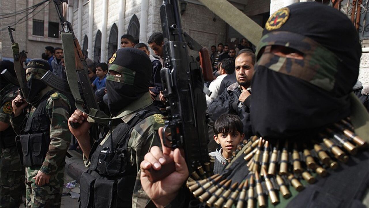 PALESTINIANS-ISRAEL/VIOLENCE Islamic jihad militants take part in the funeral of three comrades, who were killed in an Israeli air strike, in Khan Younis in the southern Gaza Strip March 11, 2014. An Israeli air strike on Tuesday killed three Palestinian militants in the Gaza Strip, the Islamic Jihad group said. The Israeli military said an Israeli aircraft targeted Islamic Jihad members who had fired a mortar bomb at its forces, and "direct hits were confirmed". REUTERS/Ibraheem Abu Mustafa (GAZA - Tags: POLITICS CIVIL UNREST) - RTR3G