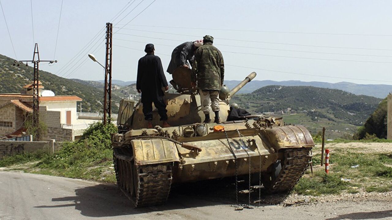 SYRIA-CRISIS/ Free Syrian Army fighters stand on a tank at the Armenian Christian town of Kasab March 28, 2014. After months of setbacks in central Syria, Islamist rebels launched an offensive last Friday into the Latakia region, taking the border crossing and the Armenian Christian village of Kasab. The border crossing at Kasab they seized had been the last point of entry from Turkey into territory fully under control of Assad's forces, since most of the northern border region is already under rebel control. REUTERS/Str