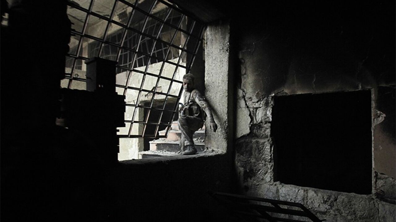 A wounded Islamist rebel fighter carries his weapon during what they said was a takeover of the Furn Al-Ali building that was under control by the Syrian regime in Ramouseh, an area located beside Aleppo Artillery school April 12, 2014. REUTERS/Ammar Abdullah (SYRIA - Tags: POLITICS CIVIL UNREST CONFLICT TPX IMAGES OF THE DAY) - RTR3L05C