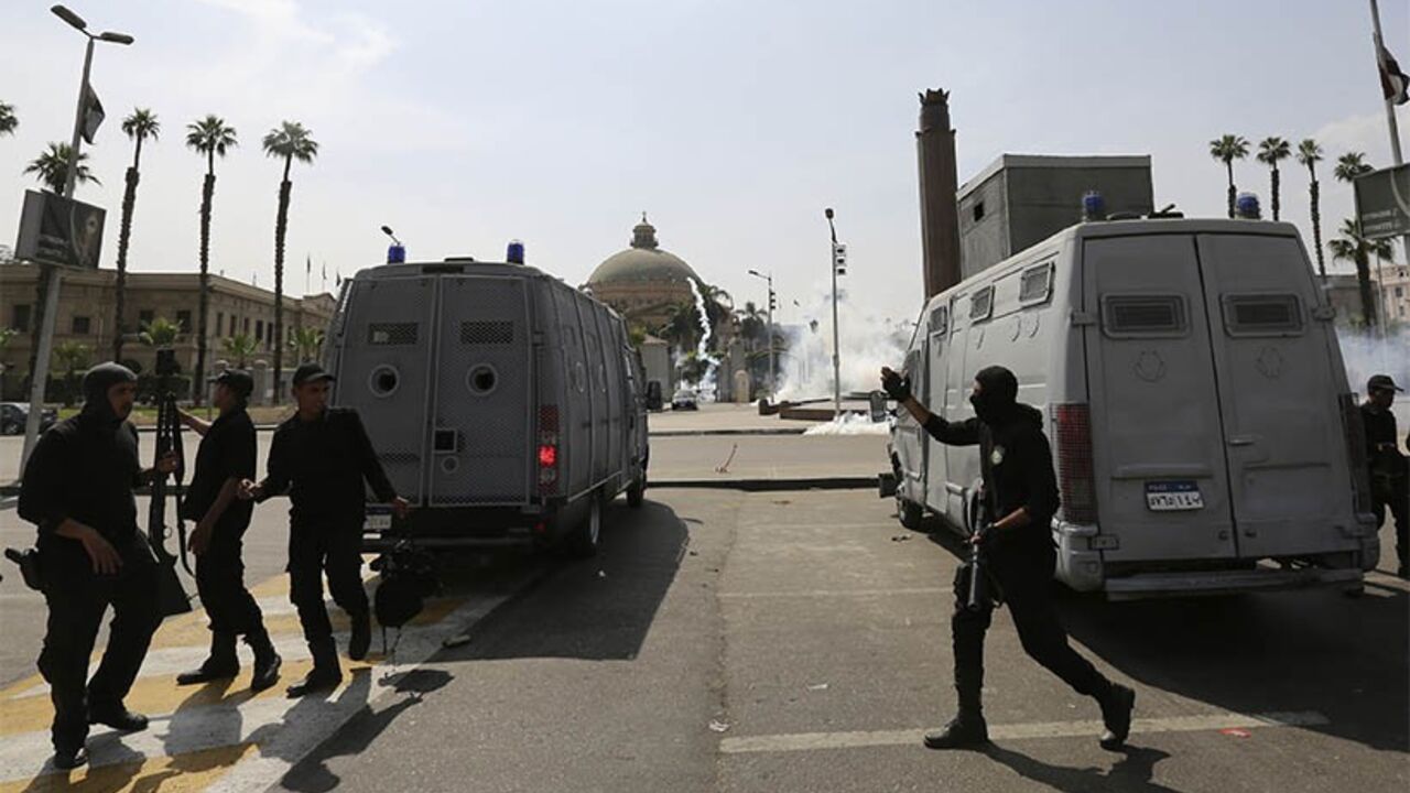EGYPT/ Riot police officers take positions as tear gas is fired during a demonstration by supporters of the Muslim Brotherhood and ousted Egyptian President Mohamed Mursi in front of Cairo University in Cairo April 14, 2014. REUTERS/Mohamed Abd El Ghany (EGYPT - Tags: CIVIL UNREST POLITICS EDUCATION) - RTR3L8GG