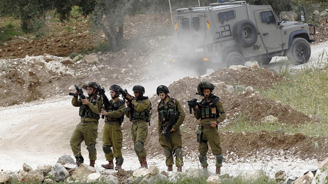 PALESTINIAN-ISRAEL/VIOLENCE Israeli soldiers check their weapons at a staging near the West Bank city of Hebron April 15, 2014. An Israeli man was killed in a shooting attack on a civilian car near the city of Hebron in the occupied West Bank on Monday, the eve of the Jewish holiday of Passover, military sources said.
REUTERS/Ammar Awad (WEST BANK - Tags: POLITICS CIVIL UNREST MILITARY TPX IMAGES OF THE DAY) - RTR3LCE0