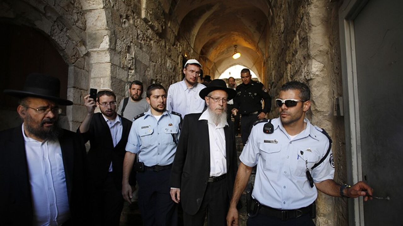 ISRAEL/ Israeli police escort Rabbi Yisrael Ariel (C) from the compound known to Muslims as Noble Sanctuary and to Jews as Temple Mount in Jerusalem's Old City October 10, 2013. An Israeli police spokesman said on Thursday three Jewish visitors, including Ariel, were detained after they failed to obey police guidelines at the compound. REUTERS/Baz Ratner (JERUSALEM - Tags: POLITICS RELIGION) - RTX145XT