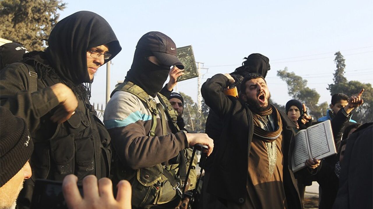 Fighters from the Islamic State in Iraq and the Levant (ISIL) try to calm civilians demonstrating against the rebel infighting in Aleppo January 6, 2014. In the last few days Syrian rebel factions battled fighters from the Islamic State in Iraq and the Levant (ISIL) across northern and eastern Syria. The apparently coordinated strikes against the ISIL come after months of increasing resentment of the powerful al Qaeda-linked group, whose radical foreign jihadis and have alienated many ordinary Syrians in re