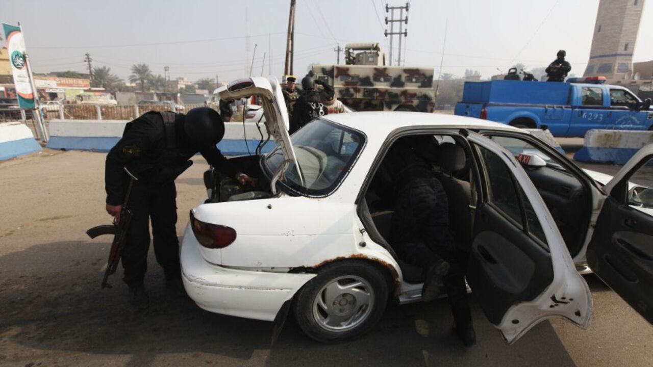 IRAQ-ATTACK/ Police officers search a vehicle at a checkpoint, as security increases after a bomb attack, at Abu Ghraib district, west of Baghdad, January 9, 2014. A suicide bomber killed 13 Iraqi army recruits and wounded more than 30 in Baghdad on Thursday, police said, in an attack on men responding to a government appeal for volunteers to help fight al Qaeda-linked militants in Anbar province. REUTERS/Ahmed Saad (IRAQ - Tags: CIVIL UNREST POLITICS MILITARY) - RTX177MB