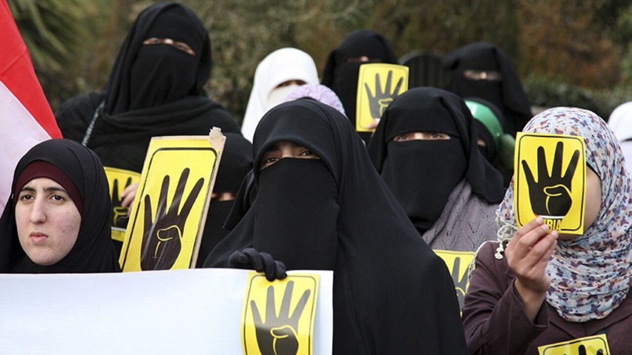 JORDAN/ Jordanian Muslim Brotherhood protesters make the 'four-fingered salute' during a protest against the Egyptian Defense Minister Abdel Fattah al-Sissi as they mark the third anniversary of the revolution, in front of the Egyptian embassy in Amman January 25, 2014. REUTERS/Majed Jaber (JORDAN - Tags: POLITICS CIVIL UNREST) - RTX17U9J