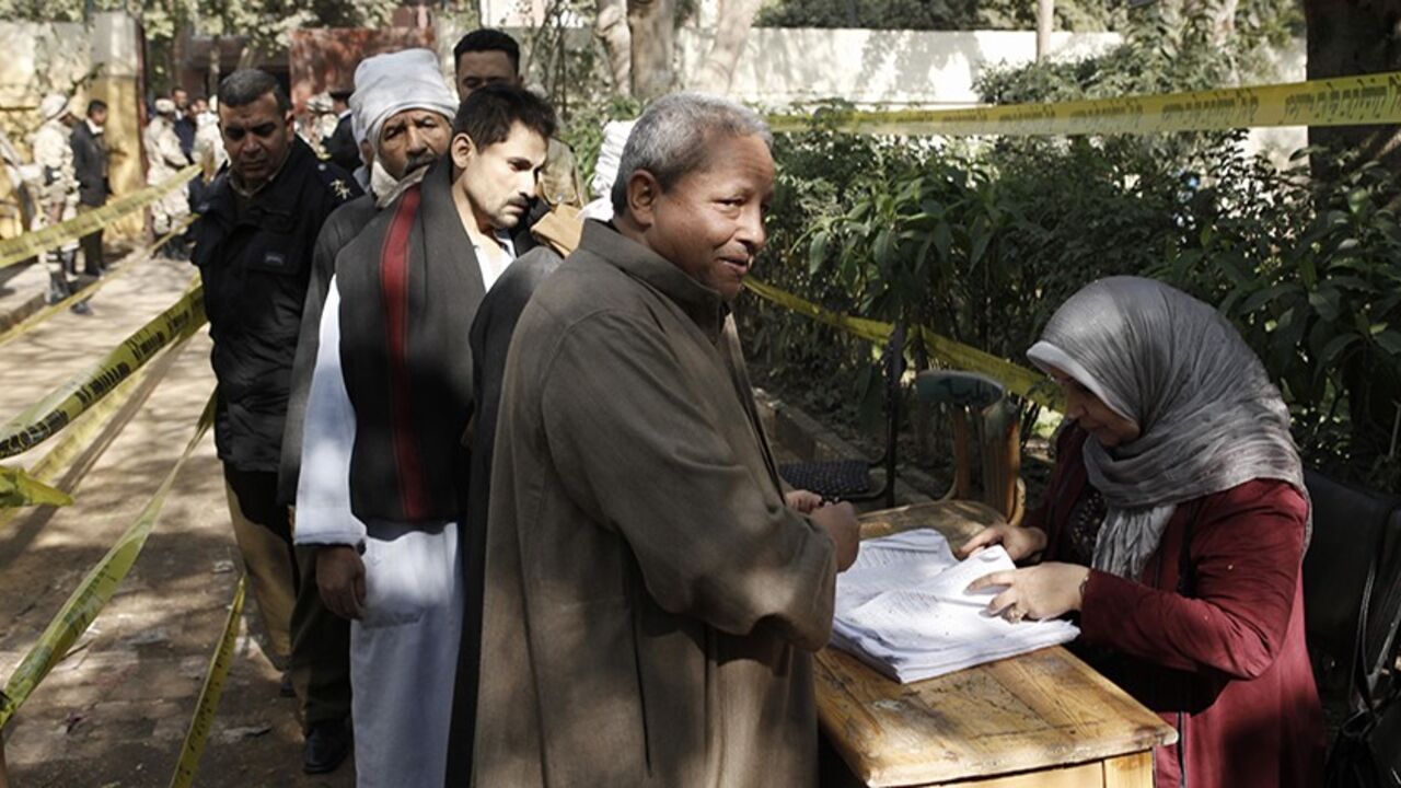 78081594 CAIRO, EGYPT - JANUARY 15: An Egyptian men stand in line to cast their votes at a polling booth on January 15, 2014 in the rural district of Fayoum, Egypt. Egyptians went to the polls for a second day today, after the first day of voting yesterday was marred by clashes between protesters and security forces, and one explosion at a courthouse, in the Egyptian capital Cairo. Egyptians are voting to decide on the third constitution for Egypt since the overthrow of former President Hosni Mubarak in February 201
