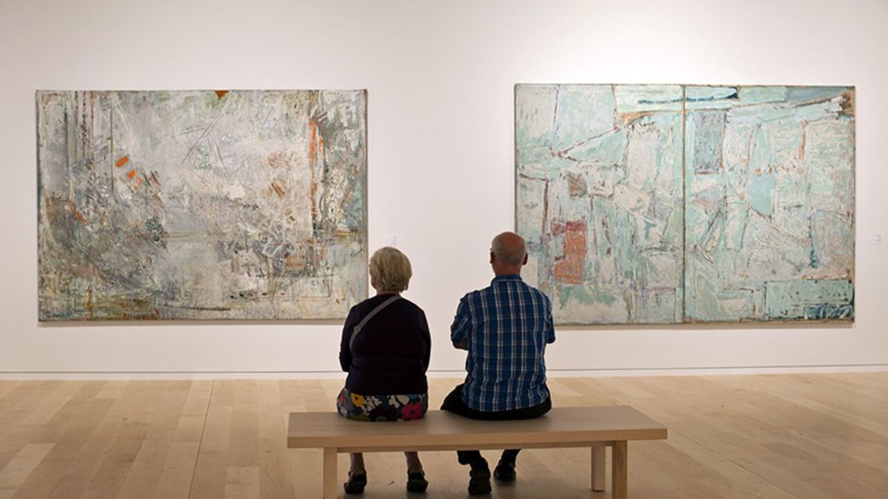 ISRAEL/ Visitors sit in front of paintings by Israeli artist Joseph Zaritsky in a section of a new wing of the Tel Aviv Museum November 2, 2011, during its official opening. The additional wing named after it's American donors Herta and Paul Amir was designed by Architect Preston Scott Cohen who heads the Harvard University Graduate School of Architecture. REUTERS/ Nir Elias (ISRAEL - Tags: SOCIETY) - RTR2TJ1H