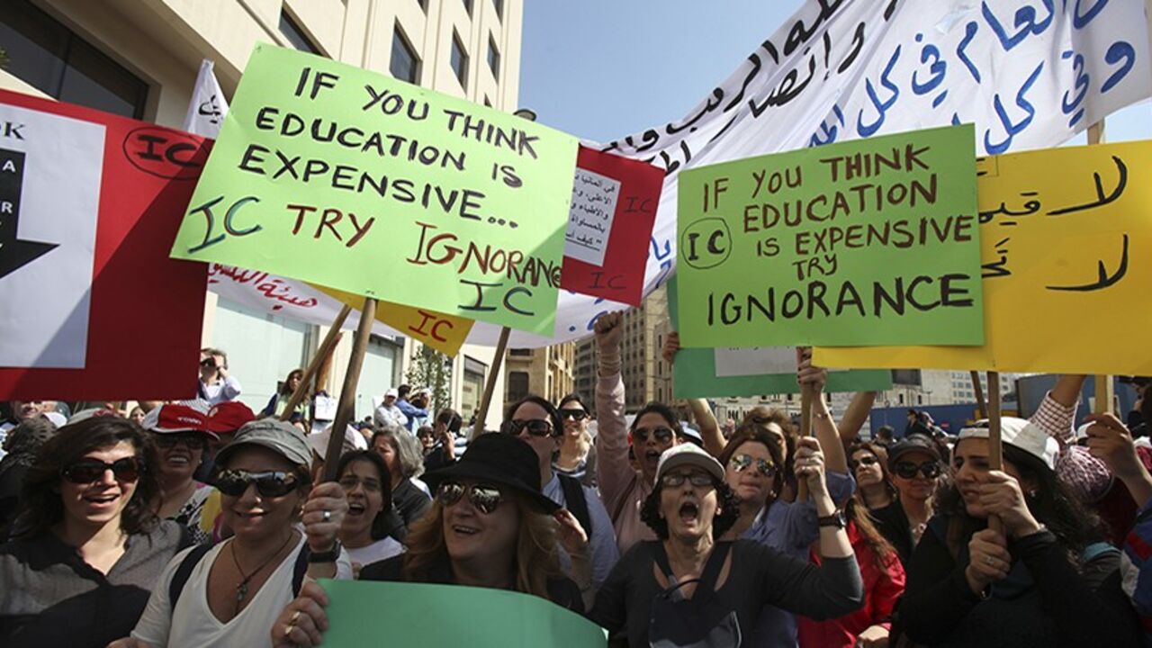 Teachers hold placards during a protest in front of the Grand Serail in Beirut, February 27, 2013. An open-ended strike by teachers and civil servants entered its second week today for the government to approve the wage hike proposal.  REUTERS/Sharif Karim (LEBANON - Tags: POLITICS EDUCATION CIVIL UNREST) - RTR3ECE2