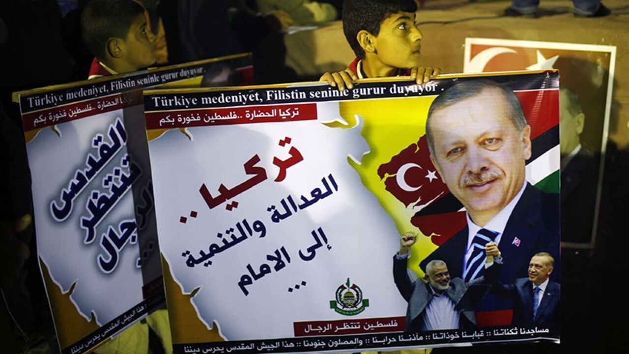TURKEY-ELECTION/ A Palestinian boy holds a poster of Turkish Prime Minister Tayyip Erdogan as he celebrates after Erdogan declared victory in local polls during a rally organised by Hamas movement in the northern Gaza Strip March 31, 2014. Erdogan declared victory in local polls that had become a referendum on his rule and said he would "enter the lair" of enemies who have accused him of corruption and leaked state secrets. The Arabic words read "Turkey Justice and development forward". REUTERS/Mohammed Salem (GAZA - Tags: