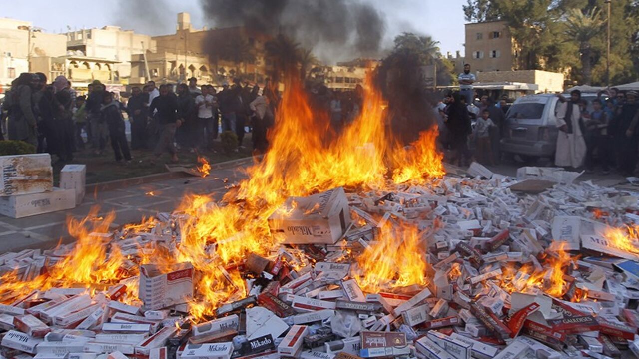 SYRIA-CRISIS/ Fighters from Islamic State in Iraq and the Levant (ISIL) burn confiscated cigarettes in the city of Raqqa April 2, 2014. REUTERS/Stringer (SYRIA - Tags: POLITICS CIVIL UNREST CONFLICT RELIGION SOCIETY TPX IMAGES OF THE DAY) - RTR3JP4Z