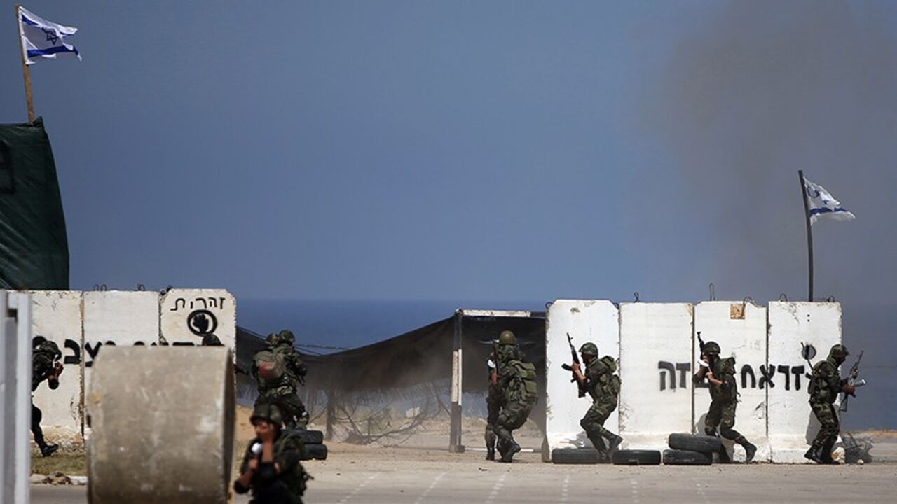 PALESTINIANS-ISRAEL/ Members of national Palestinian security forces loyal to Hamas demonstrate their skills at a scene simulating breaking into an Israeli army post during a graduation ceremony in Gaza City April 17, 2014. REUTERS/Suhaib Salem (GAZA - Tags: MILITARY POLITICS) - RTR3LN47