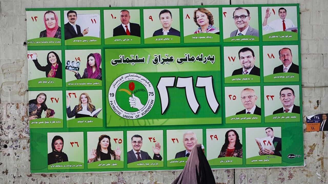IRAQ-ELECTION/KURDS A woman walks past a Patriotic Union of Kurdistan (PUK) campaign poster for Iraq's parliamentary elections in Sulaimaniya April 28, 2014. Picture taken April 28, 2014. To match IRAQ-ELECTION/KURDS REUTERS/Jacob Russell (IRAQ - Tags: POLITICS ELECTIONS TPX IMAGES OF THE DAY) - RTR3N0GU