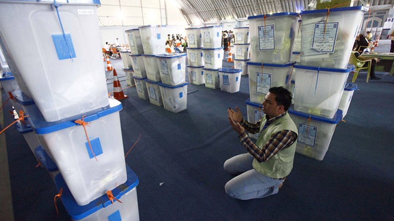 IRAQ-ELECTION/ A member of the Independent High Electoral Commission prays near ballot boxes during a vote counting at an analysis centre in Najaf, 160 km (100 miles) south of Baghdad, May 2, 2014. Iraq held a democratic vote to choose a leader with no foreign troops present for the first time on Wednesday, as Shi'ite Prime Minister Nuri al-Maliki sought to hold power for a third term in a country again consumed by sectarian bloodshed. The electoral commission said 60 percent of all voters had so far cast a ballot, accord