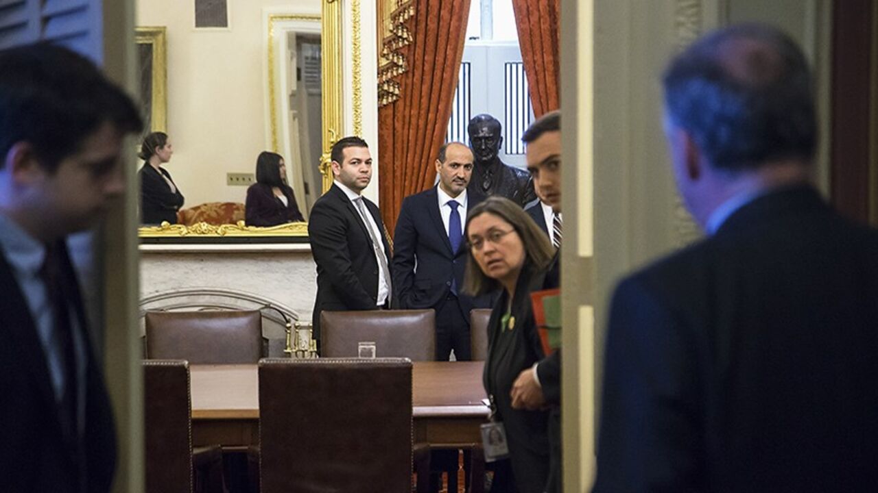 SYRIA-OBAMA/JARBA Syrian National Coalition president Ahmad Jarba (center right, in blue tie) waits to meet with U.S. Senator Robert Menendez (D-NJ) (not pictured) and members of the Senate Foreign Relations Committee, at the U.S. Capitol in Washington May 7, 2014. REUTERS/Jonathan Ernst (UNITED STATES - Tags: POLITICS) - RTR3O774