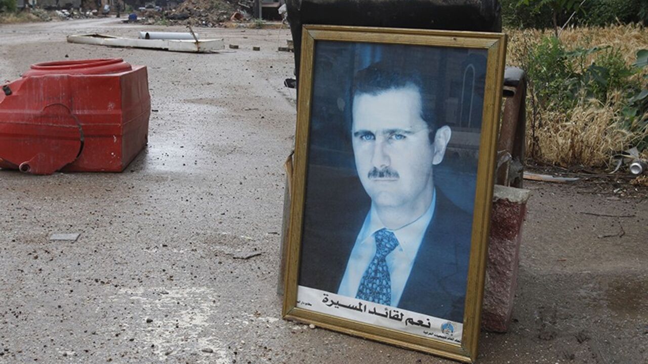 SYRIA-CRISIS/HOMS A photo of Syria's President Bashar al-Assad is seen along a street in old Homs city May 8, 2014. Syrian forces say they will take full control on Thursday over Homs, a city once vibrant with pro-democracy crowds but now associated with images of ruin that epitomise the brutality of Syria's civil war. After holding the Old City of Homs for nearly two years, close to 1,200 rebel fighters boarded buses which took them out of the "capital of the revolution" in convoys on Wednesday and Thursday, activists said.