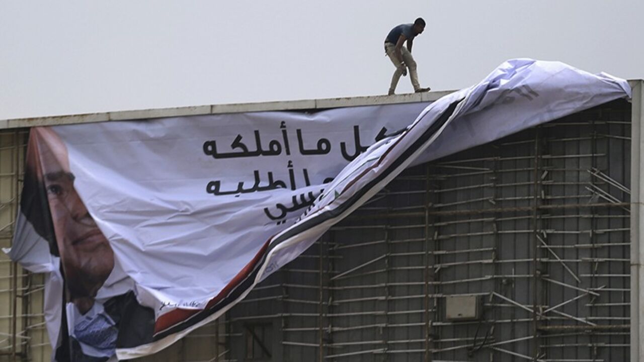 EGYPT-SISI/ A worker stands and works on a campaign billboard of presidential candidate and Egypt's former army chief Abdel Fattah al-Sisi, along a highway in Cairo May 12, 2014. An influential Qatar-based Islamist whose fiery sermons have caused tension between Gulf states said on Sunday that Egyptian presidential front runner Abdel Fattah al-Sisi will only bring downfall to the country. Sisi is expected to easily win the May 26-27 presidential election. The only other candidate is leftist politician Hamdeen Sabahi, w
