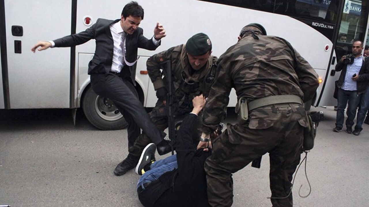 TURKEY-MINE/ A protester is kicked by Yusuf Yerkel (L), advisor to Turkey's Prime Minister Tayyip Erdogan, as Special Forces police officers detain him during a protest against Erdogan's visit to Soma, a district in Turkey's western province of Manisa May 14, 2014. Four Turkish labour unions called for a national one-day strike on Thursday in protest against the country's worst industrial disaster that killed at least 282 people in a coal mine in western Turkey. Picture taken May 14, 2014. REUTERS/Mehmet Emin Al/Depo Ph