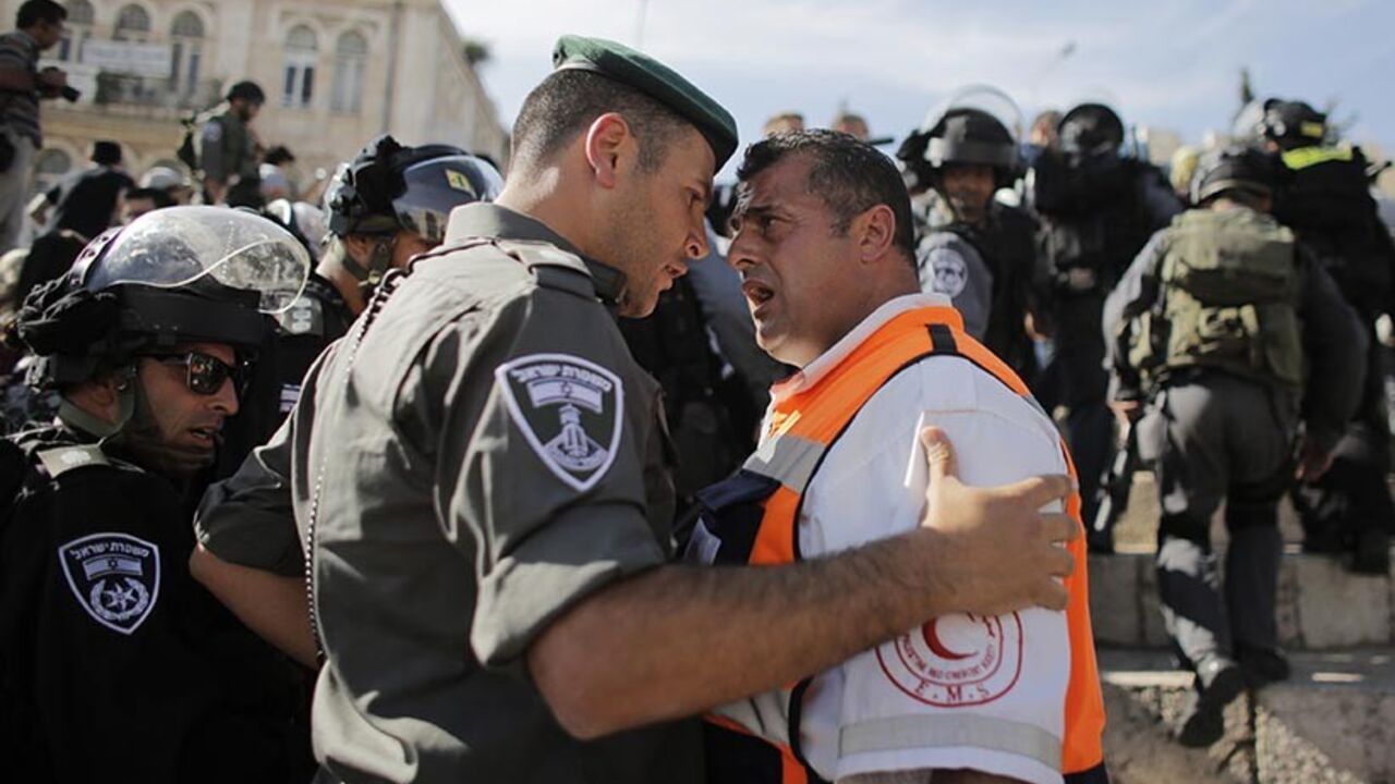 ISRAEL-PALESTINIAN/CLASHES A Palestinian medic argues with an Israeli border policeman during a demonstration marking the 66th anniversary of the "Nakba," meaning catastrophe, when many Palestinians fled or were expelled from their towns and villages during the war of Israel's foundation in 1948, at Damascus Gate in Jerusalem's Old City May 15, 2014. An Israeli police spokesman said on Thursday that 5 Palestinian protesters were detained during the unauthorized demonstration in Jerusalem's Old City, where stones were thrown at police