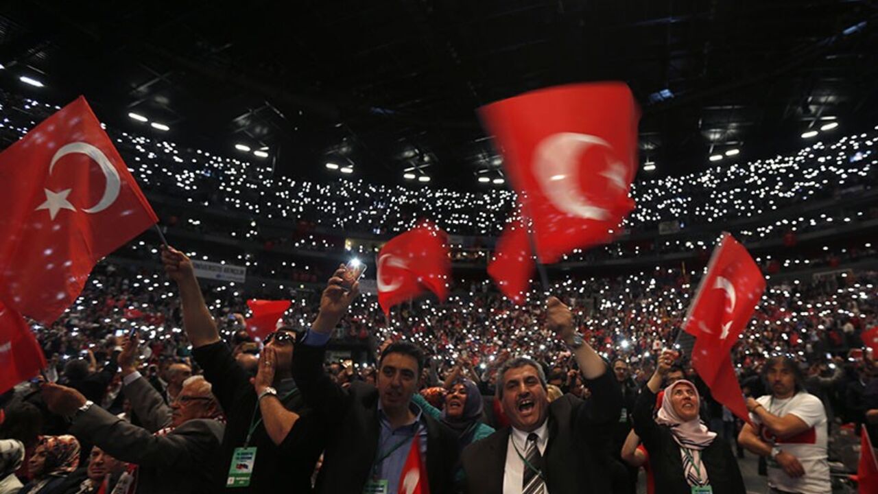 GERMANY-TURKEY/ Supporters of Turkish Prime Minister Tayyip Erdogan hold up their mobile phones and wave Turkish flags ahead of his visit in Lanxess Arena in Cologne May 24, 2014. A visit by Erdogan to Cologne on Saturday to address thousands of expatriate Turks threatens to bring Turkey's political tensions to German streets, despite an appeal by Chancellor Angela Merkel for him to adopt a sensitive tone. REUTERS/Wolfgang Rattay (GERMANY - Tags: POLITICS CIVIL UNREST TPX IMAGES OF THE DAY) - RTR3QNKQ