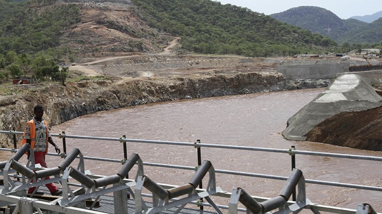 ETHIOPIA-EGYPT/NILE A man walks over a bridge by the construction of Ethiopia's Great Renaissance Dam in Guba Woreda, some 40 km (25 miles) from Ethiopia's border with Sudan, June 28, 2013. Egypt fears the $4.7 billion dam, that the Horn of Africa nation is building on the Nile, will reduce a water supply vital for its 84 million people, who mostly live in the Nile valley and delta. Picture taken June 28, 2013. REUTERS/Tiksa Negeri (ETHIOPIA - Tags: POLITICS SOCIETY ENERGY ENVIRONMENT) - RTX115K9