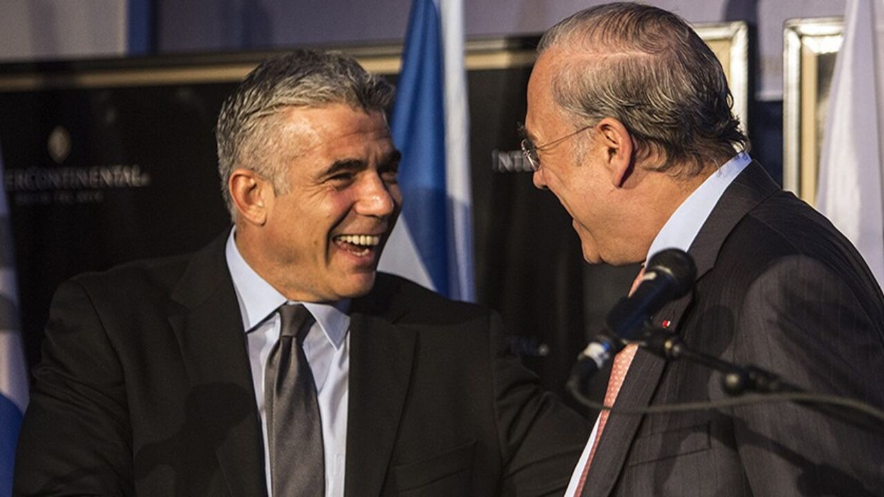 OECD-ISRAEL/ Secretary-General of the Organisation for Economic Co-operation and Development (OECD) Jose Angel Gurria (R) shakes hands with Israel's Finance Minister Yair Lapid at the end of a news conference in Tel Aviv December 8, 2013. The Bank of Israel should prepare for interest rate increases once the global economy returns to normal, the OECD said. REUTERS/Nir Elias (ISRAEL - Tags: POLITICS BUSINESS) - RTX169RL