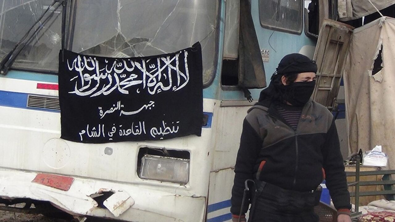 SYRIA-CRISIS/ A member of Islamist Syrian rebel group Jabhat al-Nusra mans a checkpoint on the border crossing between Syria and Jordan, which they claim to have taken control of, in Daraa December 26, 2013. Flag reads, "There is no God but Allah, and Muhammad is his prophet. Al-Nusra front, al-Qaeda in the Levant". Picture taken December 26, 2013. REUTERS/Ammar Khassawneh (SYRIA - Tags: POLITICS CIVIL UNREST CONFLICT) - RTX16VW7