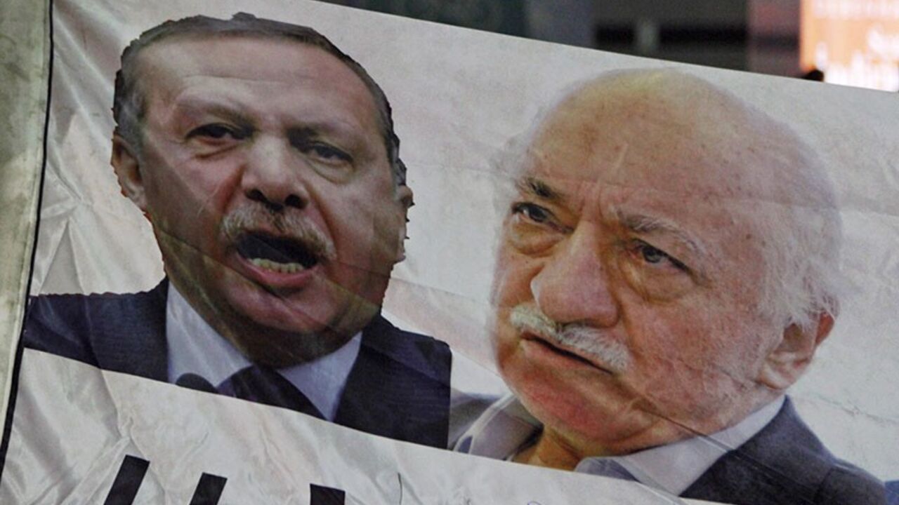 TURKEY-CORRUPTION/ A demonstrator hold pictures of Turkey's Prime Minister Tayyip Erdogan and Turkish cleric Fethullah Gulen (R), during a protest against Turkey's ruling AK Party (AKP), demanding the resignation of Erdogan, in Istanbul December 30, 2013. Erdogan swore on Sunday he would survive a corruption crisis circling his cabinet, saying those seeking his overthrow would fail just like mass anti-government protests last summer. Gulen denies involvement in stirring up the graft case, but he regularly censures Erdogan, a