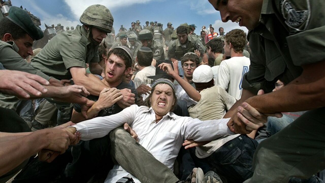 MIDEAST Jewish settlers scuffle with Israeli border police attempting to remove the Jewish outpost of Mitzpeh Yitzhar in the West Bank May 17, 2004. Israeli troops clashed on Monday with hundreds of Jewish settlers trying to prevent the dismantling of an unauthorised settlement outpost in the West Bank. - RTXMM3O