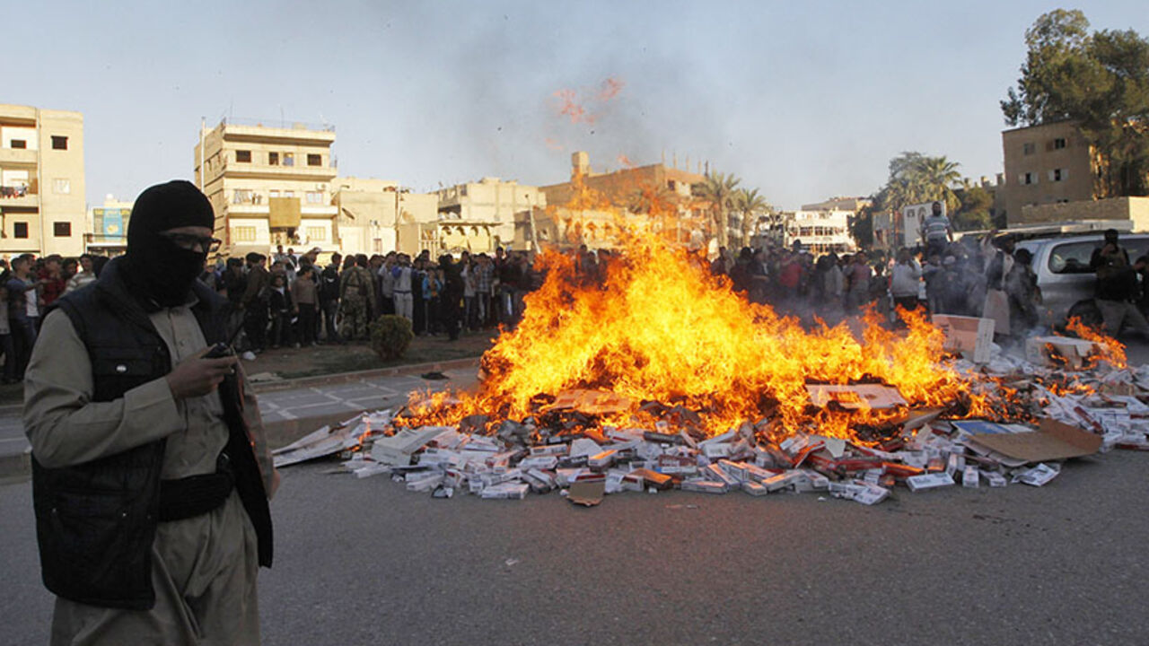 A fighter from Islamic State in Iraq and the Levant stands near burning confiscated cigarettes in the city of Raqqa A fighter from Islamic State in Iraq and the Levant (ISIL) stands near burning confiscated cigarettes in the city of Raqqa April 2, 2014. REUTERS/Stringer (SYRIA - Tags: POLITICS CIVIL UNREST CONFLICT RELIGION SOCIETY) - RTR3JOPD
