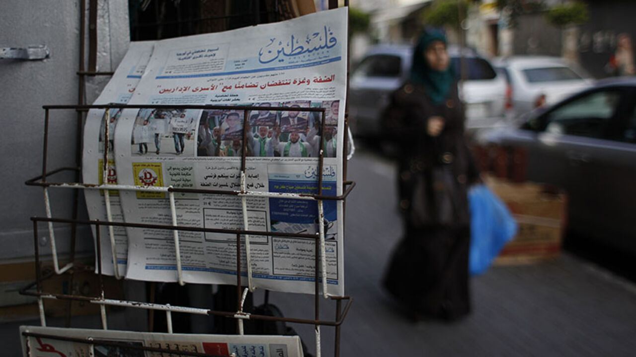 A Palestinian woman walks past copies of a pro-Hamas newspaper, Palestine, displayed outside a shop in the West Bank city of Ramallah A Palestinian woman walks past copies of a pro-Hamas newspaper, Palestine, displayed outside a shop in the West Bank city of Ramallah May 10, 2014. The Palestinian authority had allowed the distribution of the pro-Hamas Palestine newspaper in the West Bank on Saturday after the Hamas-run government in the Gaza Strip said on Wednesday it had relaxed a ban on Palestinian newspapers published outside the enclave as a gesture of reconciliation to rival group Fatah after their unity deal last month. REUTERS/Moha