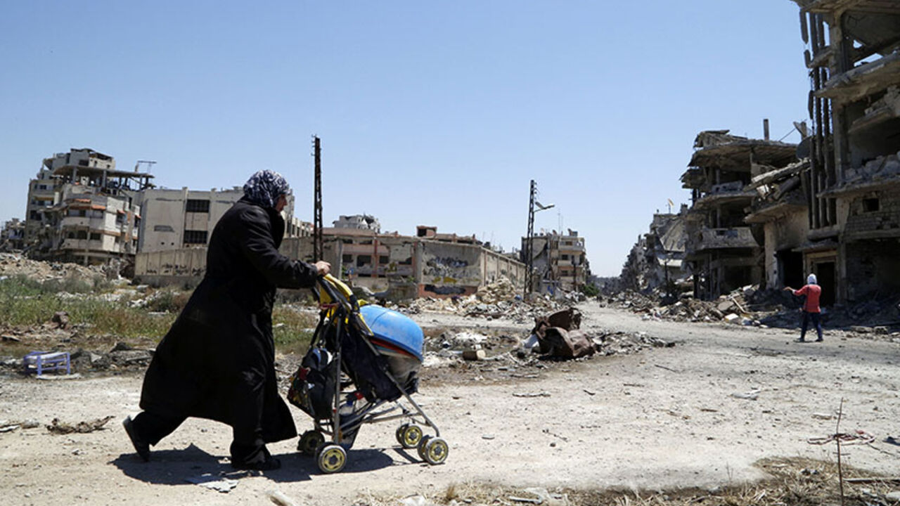 Woman pushes a baby's stroller loaded with belongings recovered from her home in the Wadi Al-Sayeh district at the al-Khalidiyeh area in Homs A woman pushes a baby's stroller loaded with belongings recovered from her home in the Wadi Al-Sayeh district at the al-Khalidiyeh area in Homs May 14, 2014. The fall of Syria's third largest city to government forces is a major blow to the opposition and a boost for Assad, weeks before his likely re-election. Picture taken May 14, 2014. REUTERS/Omar Sanadiki (SYRIA - Tags: CIVIL UNREST CONFLICT) - RTR3PD8B