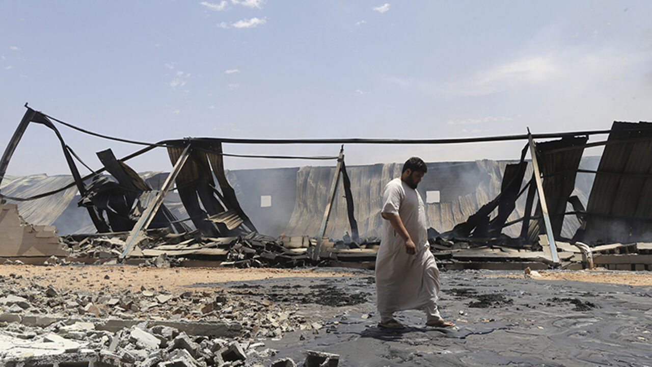 A man walks past destroyed warehouses following Friday's clashes between Libyan irregular forces and Islamist militias in Benghazi A man walks past destroyed warehouses following Friday's clashes between Libyan irregular forces and Islamist militias in the eastern city of Benghazi May 17, 2014. REUTERS/Esam Omran Al-Fetori (LIBYA - Tags: CIVIL UNREST POLITICS) - RTR3PL90