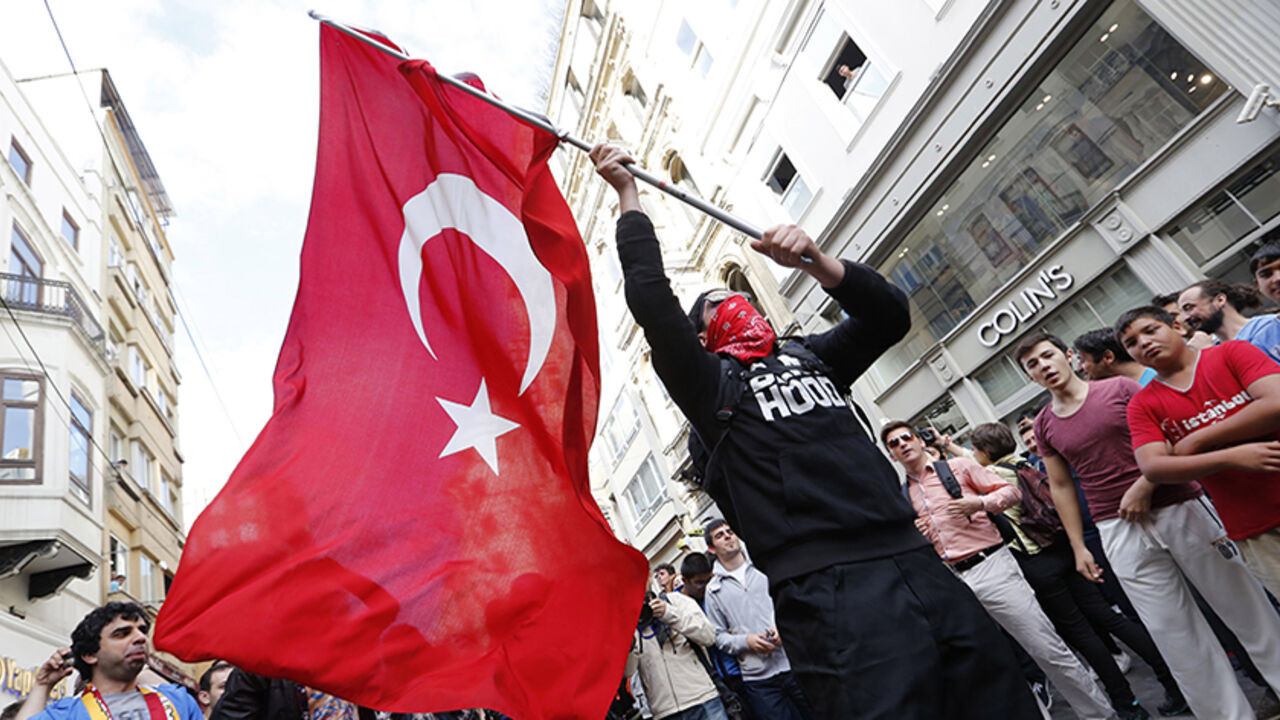A masked demonstrator waves a Turkish flag during a protest in central Istanbul A masked demonstrator waves a Turkish flag during a protest in central Istanbul May 31, 2014. On the first anniversary of nationwide protests that shook Prime Minster Tayyip Erdogan's rule, barely a thousand anti-government demonstrators marched in Istanbul on Saturday. Outnumbered by riot police, they were soon sent scurrying into side streets by tear gas and water cannon. Their scant numbers were an illustration of Erdogan's tightening grip on power despite a year punctuated by street protests, internatio
