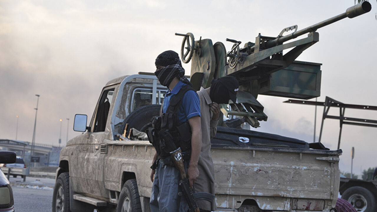 Fighters of the Islamic State of Iraq and the Levant (ISIL) stand guard at a checkpoint in the northern Iraq city of Mosul Fighters of the Islamic State of Iraq and the Levant (ISIL) stand guard at a checkpoint in the northern Iraq city of Mosul, June 11, 2014. Since Tuesday, black clad ISIL fighters have seized Iraq's second biggest city Mosul and Tikrit, home town of former dictator Saddam Hussein, as well as other towns and cities north of Baghdad. They continued their lightning advance on Thursday, moving into towns just an hour's drive from the capital. Picture taken June 11, 2014. REUTERS/Stringer (IRAQ - Tags: CIVIL UNRE