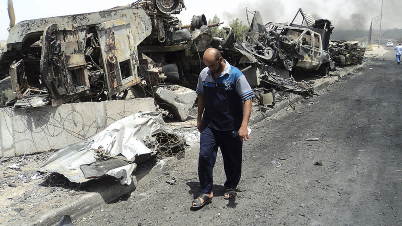 A man walks past near remains of burnt vehicles belonging to Iraqi security forces in the northern Iraq city of Mosul A man walks past near remains of burnt vehicles belonging to Iraqi security forces in the northern Iraq city of Mosul, June 13, 2014. A Sunni Islamist offensive threatening to dismember Iraq seemed to slow on Saturday after days of lightning advances as government forces reported regaining territory in counter-attacks, easing pressure on Baghdad's Shi'ite-led government. Picture taken June 13, 2014. REUTERS/Stringer (IRAQ - Tags: CIVIL UNREST POLITICS) - RTR3TR9S