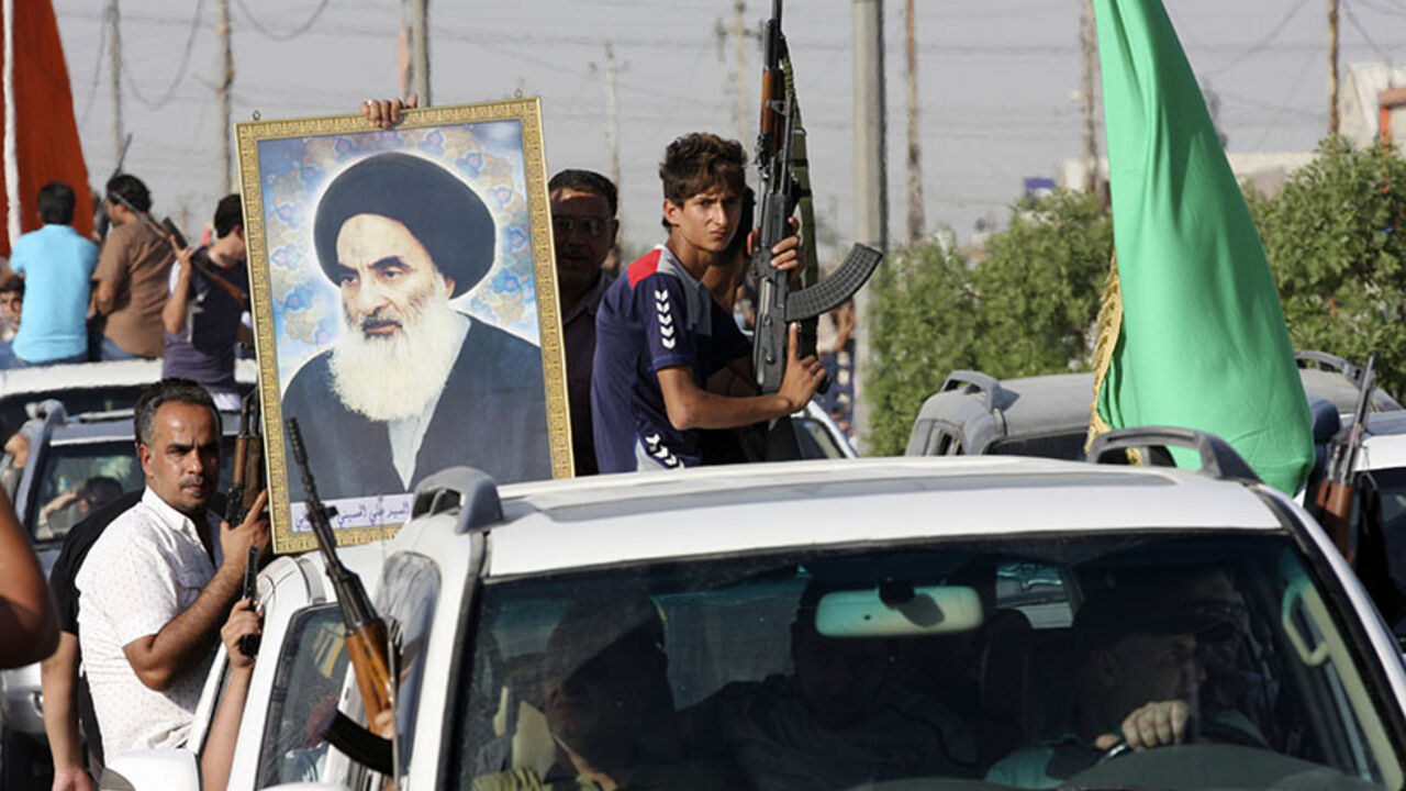 Volunteers, who have joined the Iraqi Army to fight against predominantly Sunni militants, carry weapons and a portrait of Grand Ayatollah Ali al-Sistani during a parade in Sadr city Volunteers, who have joined the Iraqi Army to fight against predominantly Sunni militants, carry weapons and a portrait of Grand Ayatollah Ali al-Sistani during a parade in the streets in Baghdad's Sadr city June 14, 2014. An offensive by insurgents that threatens to dismember Iraq seemed to slow on Saturday after days of lightning advances as government forces regained some territory in counter-attacks, easing pressure on the Shi'ite-led government in Baghdad. REUTERS/Wissm al-Okili (IRAQ - Tags: CIVIL