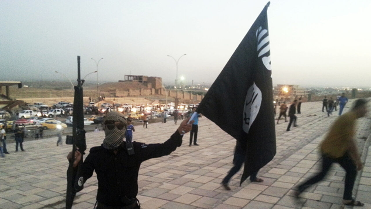 A fighter of the ISIL holds a flag and a weapon on a street in Mosul A fighter of the Islamic State of Iraq and the Levant (ISIL) holds an ISIL flag and a weapon on a street in the city of Mosul, June 23, 2014. U.S. Secretary of State John Kerry held crisis talks with leaders of Iraq's autonomous Kurdish region on Tuesday urging them to stand with Baghdad in the face of a Sunni insurgent onslaught that threatens to dismember the country. Picture taken June 23, 2014. REUTERS/Stringer (IRAQ - Tags: CIVIL UNREST POLITICS TPX IMAGES OF THE DAY) - RTR3VIB1