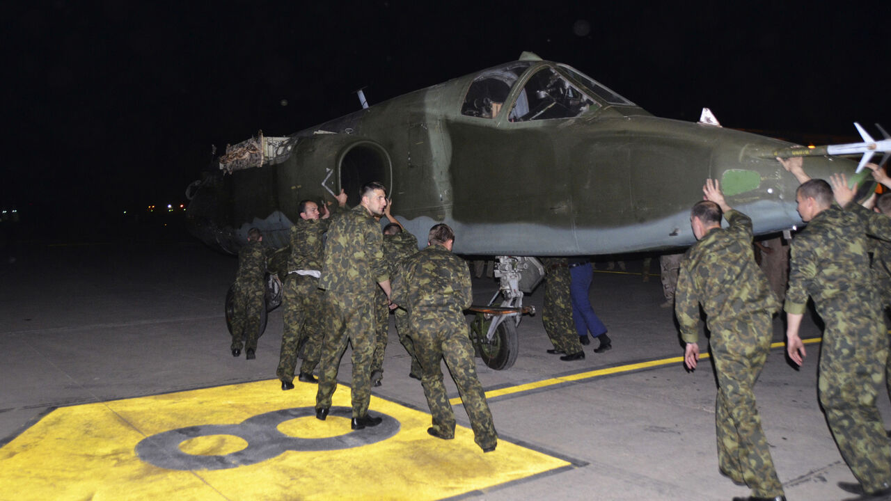 Russian soldiers unload a Russian Sukhoi SU-25 plane in al-Muthanna Iraqi military base at Baghdad airport in Baghdad, June 28, 2014. The first batch of Russian fighter jets arrived in Baghdad on Saturday to help Iraqi forces battle Islamic State of Iraq and the Levant (ISIL) fighters in the country's north. Picture taken June 28, 2014.  REUTERS/Stringer (IRAQ - Tags: POLITICS MILITARY TRANSPORT CIVIL UNREST CONFLICT) - RTR3W9NZ