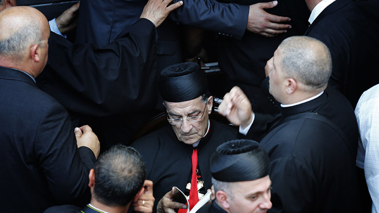 Maronite Patriarch Beshara al-Rai reads as he is surrounded by security personnel during his a visit to Birim, a northern Israeli village Maronite Patriarch Beshara al-Rai reads as he is surrounded by security personnel during his a visit to Birim, a northern Israeli village whose Maronite Christian residents were displaced 66 years ago May 28, 2014. The Lebanese church leader who defied warnings from the powerful Shi'ite Muslim Hezbollah movement by accompanying the Pope on a Holy Land visit pledged on Wednesday to help dispossessed Christians in Israel. REUTERS/Finbarr O'Reilly (ISRAEL - Tags: RELIGION POLITICS TPX IMAGES OF THE DAY) - RTR