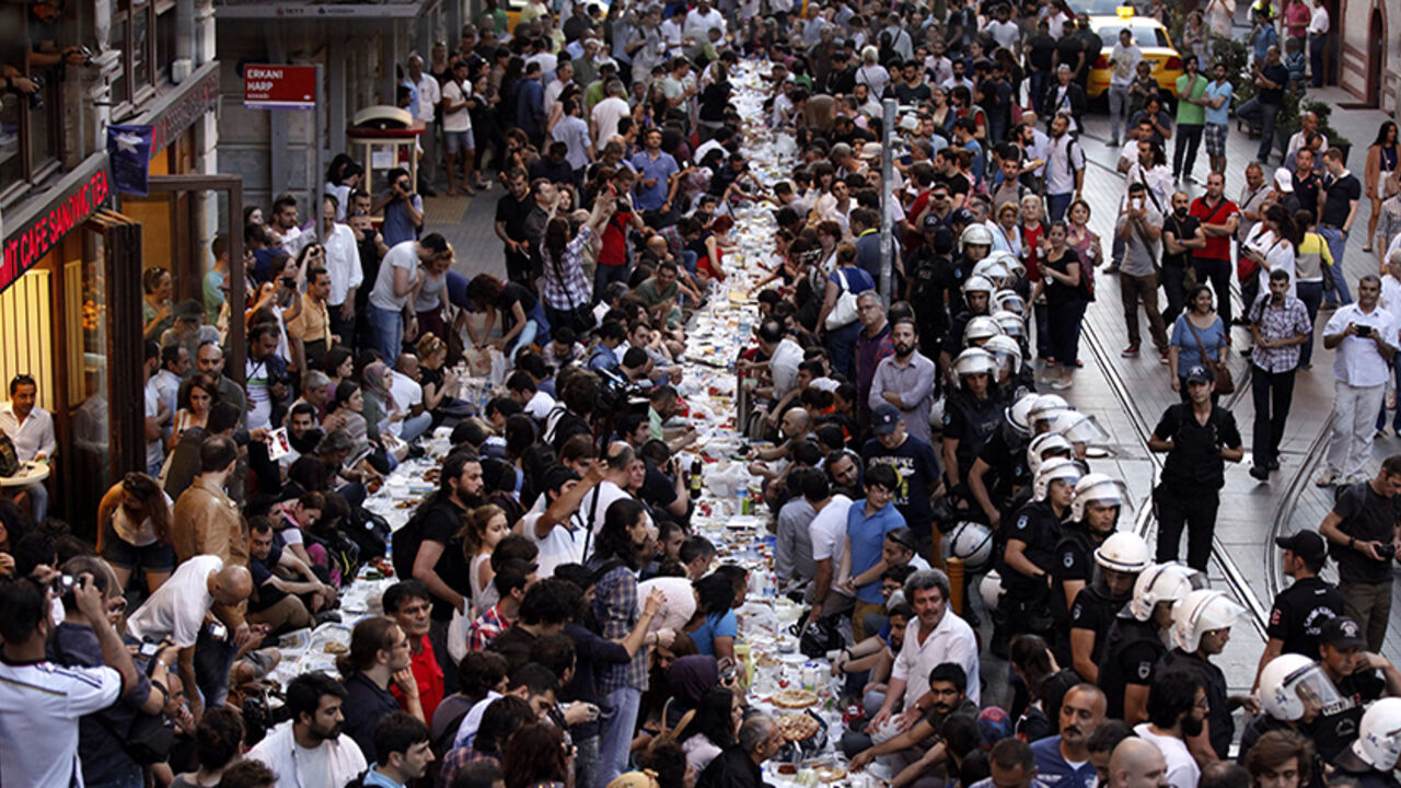 People prepare to break their fast during Ramadan as police officers stand guard in Istanbul People prepare to break their fast on the first day of the holy month of Ramadan as police officers stand guard at near Taksim Square in Istanbul June 28, 2014. REUTERS/Osman Orsal (TURKEY - Tags: POLITICS CIVIL UNREST RELIGION) - RTR3W810