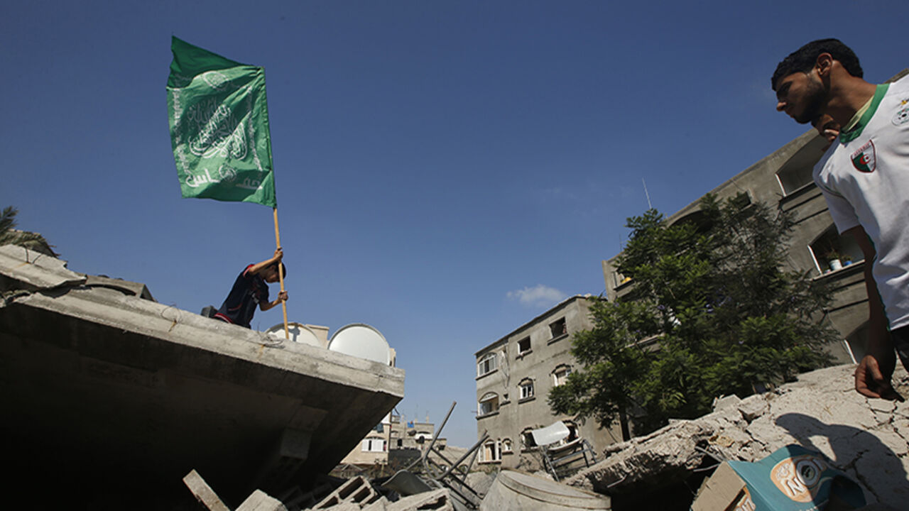 A Palestinian boy places a Hamas flag atop the rubble of a house which police said was destroyed in an Israeli air strike in the northern Gaza Strip A Palestinian boy places a Hamas flag atop the rubble of a house which police said was destroyed in an Israeli air strike in the northern Gaza Strip July 9, 2014. At least 23 people were killed across Gaza, Palestinian officials said on Wednesday, by a bombardment Israel said may be just the start of a lengthy offensive against Islamist militants whose rockets struck deeper than ever before into Israel. REUTERS/Mohammed Salem (GAZA - Tags: POLITICS CIVIL UNREST) - RTR3XQSM