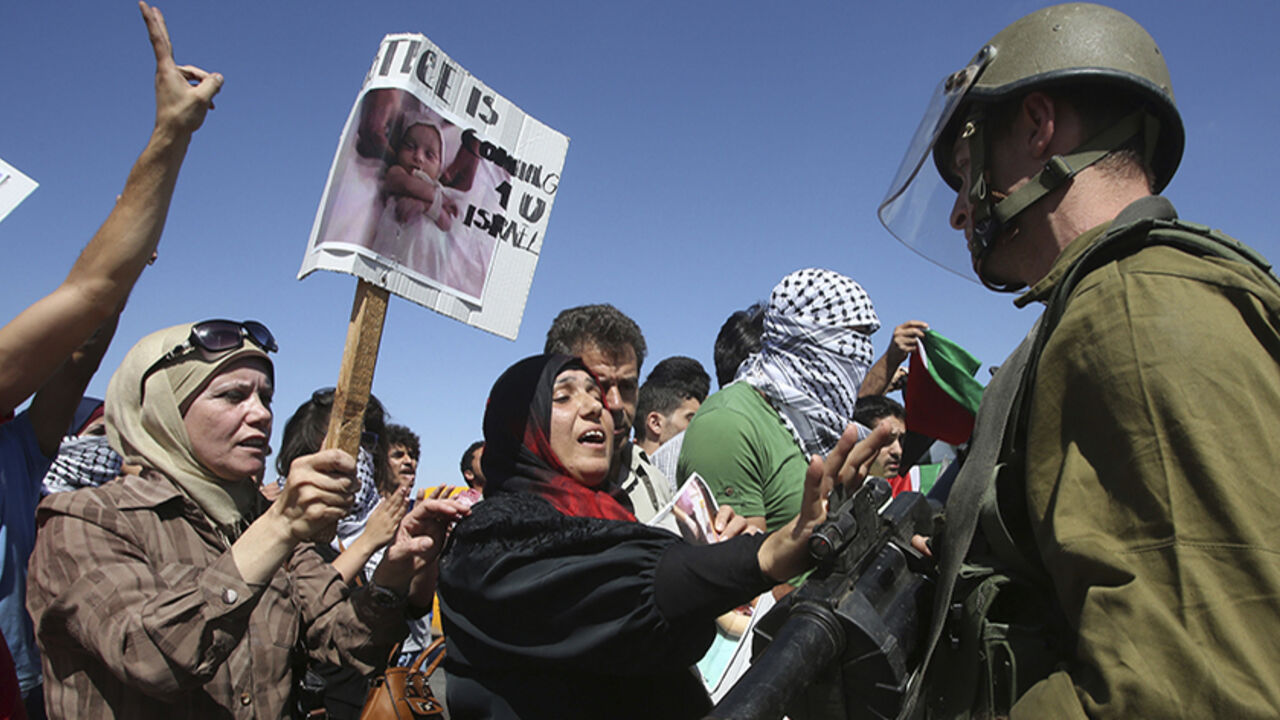 Palestinian protesters argue with Israeli soldiers during a protest against the Israeli air strikes in Gaza strip, at Hawara checkpoint near the West Bank city of Nablus, July 14, 2014. Palestinian militants resumed rocket attacks on Tel Aviv on Monday after a 24-hour lull in strikes on the Israeli commercial capital, and Israel kept up its air and naval bombardments of the Gaza Strip despite growing international pressure for a ceasefire. Around half a dozen Israelis have been wounded since the start of th